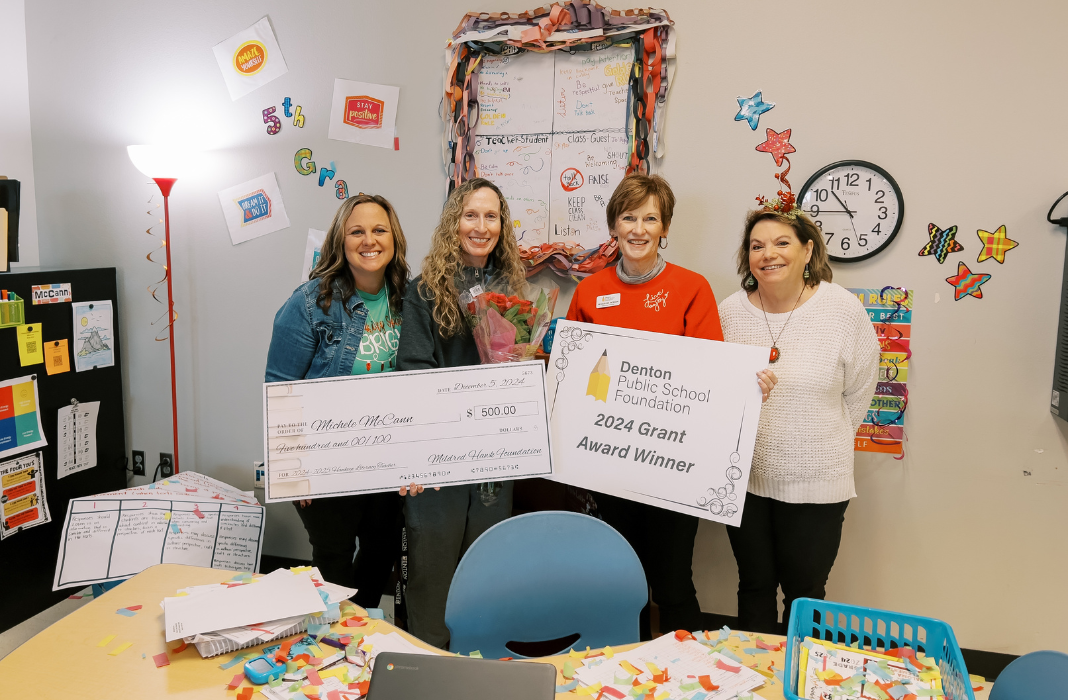 Dento ISD see staff holding a check