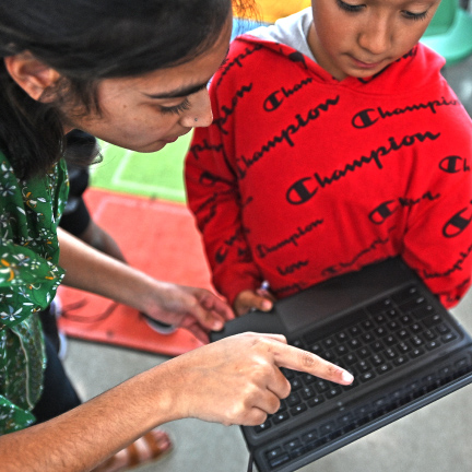 student and staff looking at laptop